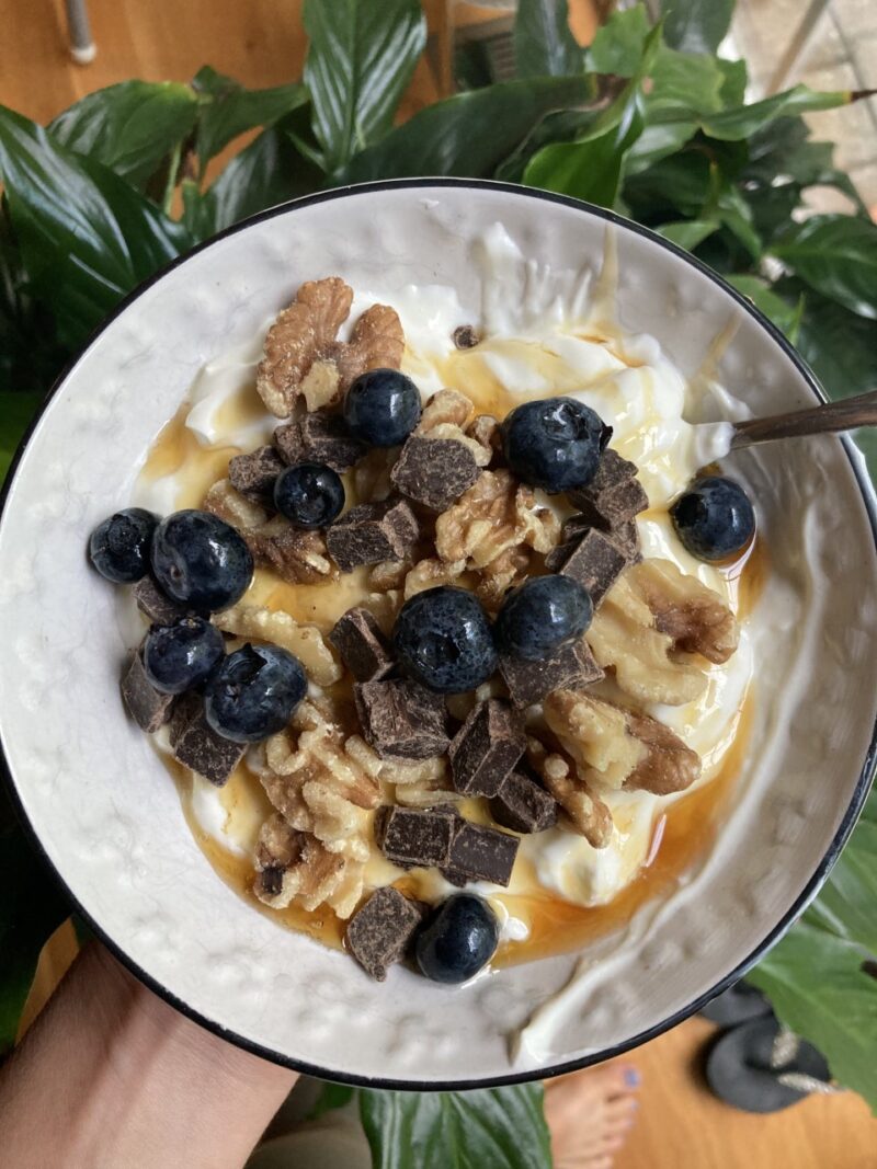 Breakfast bowl with walnuts, honey, blueberries, and chocolate chunks